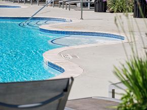 Conroe apartment for rent - A pool with a chair and a table nearby.