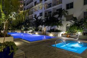 Ft. Lauderdale apartment for rent - A pool surrounded by plants and trees at night.