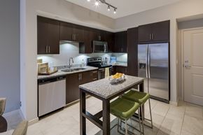 Ft. Lauderdale apartment for rent - A kitchen with a table and chairs in front of a refrigerator.