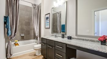 Well-appointed bathrooms with framed vanity mirrors and soaking tub with tile bath surrounds