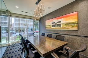 Los Angeles apartment for rent - A conference room with a long table and chairs, a chandelier, and a large painting on the wall.