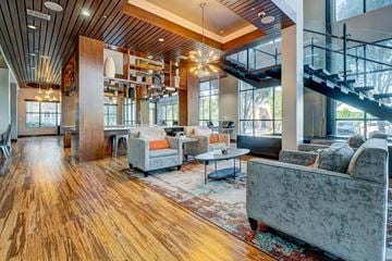 Durham apartment for rent - A living room with a grey couch and a wooden floor.