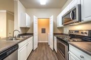 Fairfield apartment for rent - A kitchen with white cabinets and black appliances.