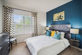 Northglenn apartment for rent - A bedroom with a large bed and a window with curtains.
