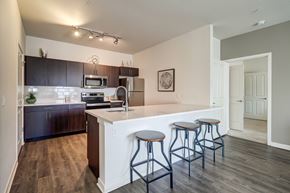 Northglenn apartment for rent - A kitchen with a white counter and bar stools.