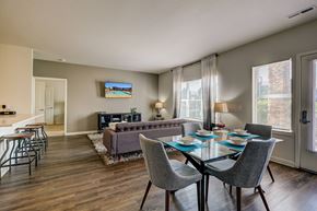 Northglenn apartment for rent - A modern dining room with a glass table and grey chairs.