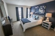 Gahanna apartment for rent - A bedroom with a large bed and a nightstand with a lamp.