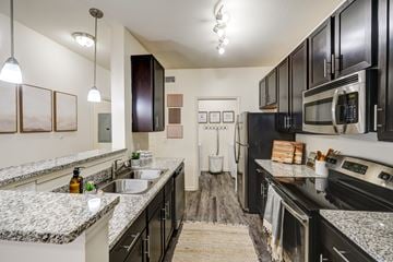 Smyrna apartment for rent - A kitchen with black cabinets and granite countertops.