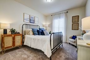 Smyrna apartment for rent - A bedroom with a white bed and a wooden cabinet.