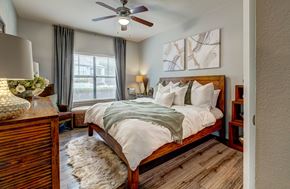Round Rock apartment for rent - A bedroom with a large bed and a ceiling fan.