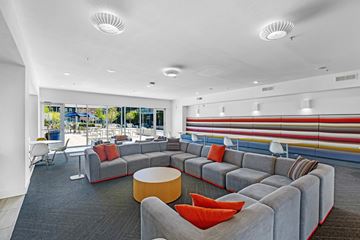 Birmingham apartment for rent - A modern living room with grey couches and red pillows.