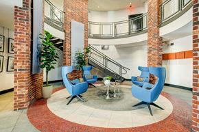 Houston apartment for rent - A large open space with a staircase and two blue chairs.
