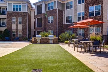 Fuquay-Varina apartment for rent - A patio with a table and chairs and a red umbrella.