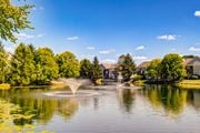 Dublin apartment for rent - A serene lake with a fountain in the middle surrounded by lush green trees.