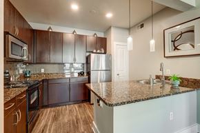 Austin apartment for rent - A kitchen with brown cabinets and a granite countertop.