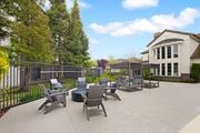 Fairfield apartment for rent - A patio with chairs and a table is surrounded by a fence and trees.