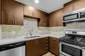 Los Angeles apartment for rent - A kitchen with brown cabinets and a stone backsplash.