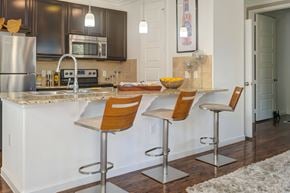 Lakeway apartment for rent - A kitchen with a white counter top and brown bar stools.