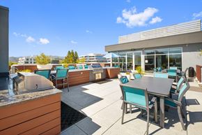 Walnut Creek apartment for rent - A patio with a table and chairs is surrounded by buildings.