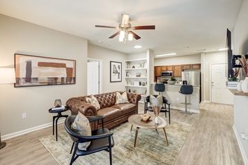 Atlanta apartment for rent - A living room with a brown couch and a ceiling fan.