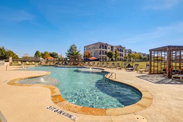 Aubrey apartment for rent - A large outdoor swimming pool with a sign that says "STEAMBOAT".