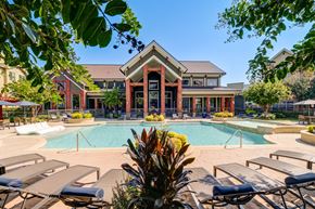 Houston apartment for rent - A pool area with sun loungers and a building in the background.