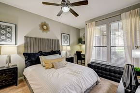 Houston apartment for rent - A bedroom with a large bed and a ceiling fan.
