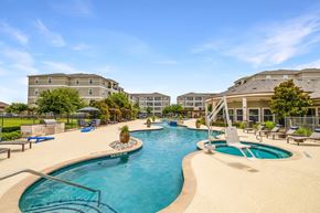 Wylie apartment for rent - A large outdoor swimming pool with a slide and sun loungers.
