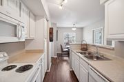 Littleton apartment for rent - A kitchen with white cabinets and a stove top oven.