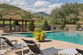 Littleton apartment for rent - A pool surrounded by chairs and a mountain in the background.
