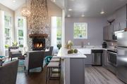 Snoqualmie apartment for rent - A modern kitchen with a stone fireplace and a dining table set for four.