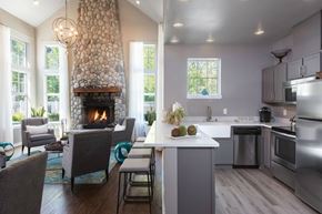 Snoqualmie apartment for rent - A modern kitchen with a stone fireplace and a dining table set for four.