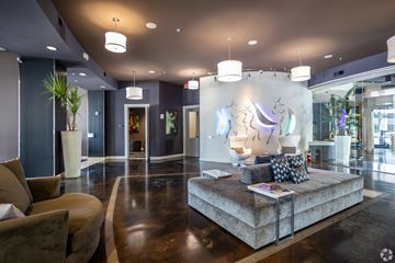 Dallas apartment for rent - A modern living room with a brown sofa and a large artwork on the wall.