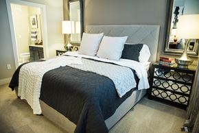 Dallas apartment for rent - A bedroom with a large bed and a nightstand with a lamp.