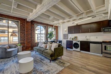 Los Angeles apartment for rent - A living room with a green couch and a wooden floor.