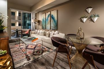 Los Angeles apartment for rent - A living room with a white sofa, a glass coffee table, and a large abstract painting on the wall.