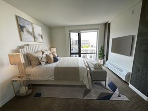 San Francisco apartment for rent - A bedroom with a large bed and a window overlooking the city.