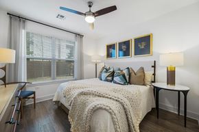 Plymouth apartment for rent - A bedroom with a bed, a chair, a table, and a window.