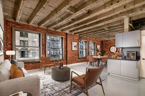 Los Angeles apartment for rent - A modern living room with a brick wall and wooden ceiling.
