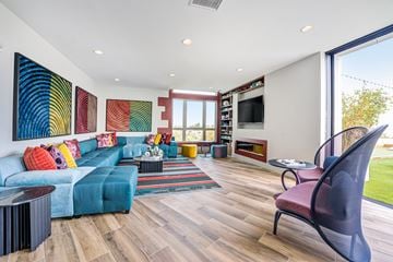 San Diego apartment for rent - A living room with a blue couch and a large painting on the wall.