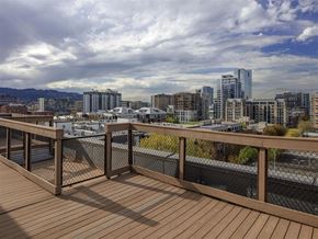Portland apartment for rent - A wooden deck overlooks a cityscape with buildings and a cloudy sky.