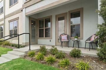 Rowlett apartment for rent - A house with a white front porch and a black railing.