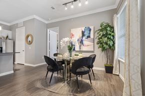 Rowlett apartment for rent - A dining room with a table set for two and a potted plant.