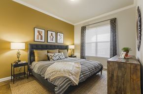 Aubrey apartment for rent - A bedroom with a large bed and a wooden dresser.