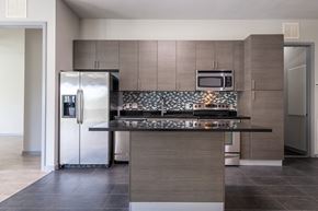 Heathrow apartment for rent - A modern kitchen with a stainless steel refrigerator and microwave above the counter.