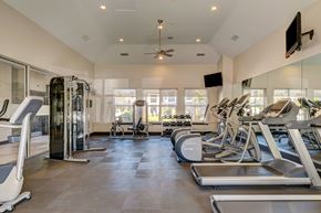Westminster apartment for rent - A spacious gym with treadmills, elliptical machines, and a television.