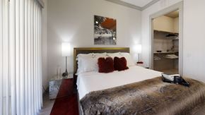 Rowlett apartment for rent - A bedroom with a large bed and a painting on the wall.