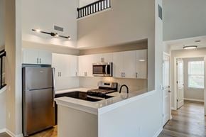 Hackensack apartment for rent - A modern kitchen with white cabinets and a stainless steel refrigerator.