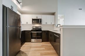Hackensack apartment for rent - A modern kitchen with a stainless steel refrigerator and wooden flooring.