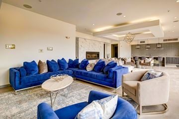 Heathrow apartment for rent - A living room with blue couches and a fireplace.